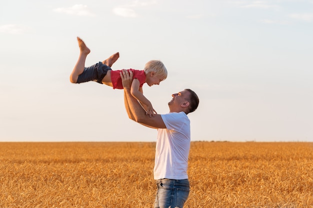 Vater spielt mit Sohn im Weizenfeld