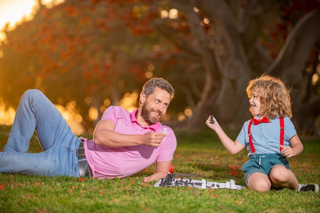 Vater spielt Schach mit Sohn Familie außerhalb des Spiels Intelligentes Kind, intelligente Kinder