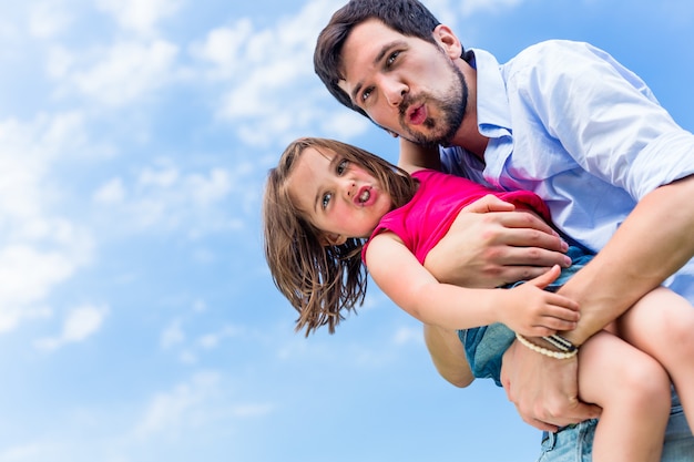 Vater trägt die Tochter, die sie beschützt