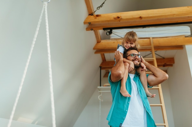 Foto vater trägt seine tochter zu hause auf den schultern und ist wirklich glücklich