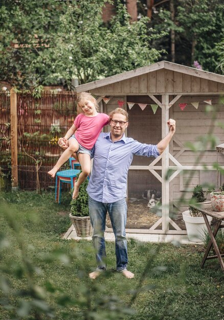 Vater trägt Tochter im Garten