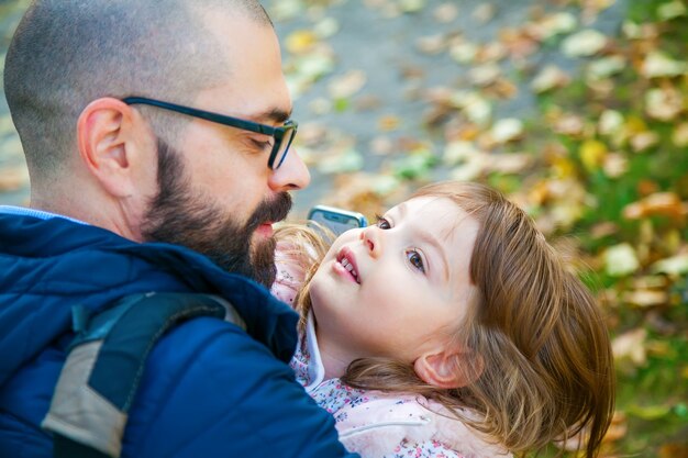 Vater umarmt seine süße kleine Tochter im Freien