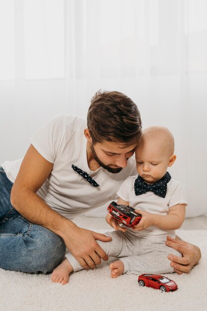 Foto vater und baby spielen zu hause zusammen