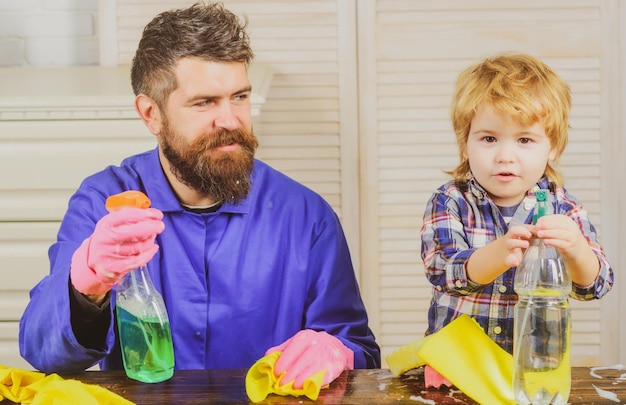 Vater und Kind haben Spaß beim Putzen. Mann mit Kind spielt mit Seifenlauge. Vater bringt einem Sohn eine Reinigung bei. Man gewöhnt den Jungen an Sauberkeit.