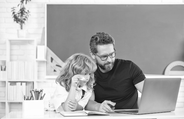 Vater und Kind lernen im Klassenzimmer mit Laptop-Familie