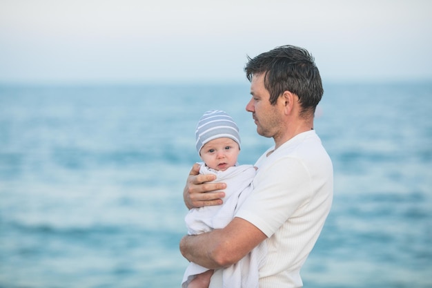 Vater und Kind spielen bei Sonnenuntergang am tropischen Strand Familienurlaub im Ferienort am Meer Vater spielt mit Kindern an einem sonnigen Abend am Meer an der Küste Reisen mit Kindern Elternliebe