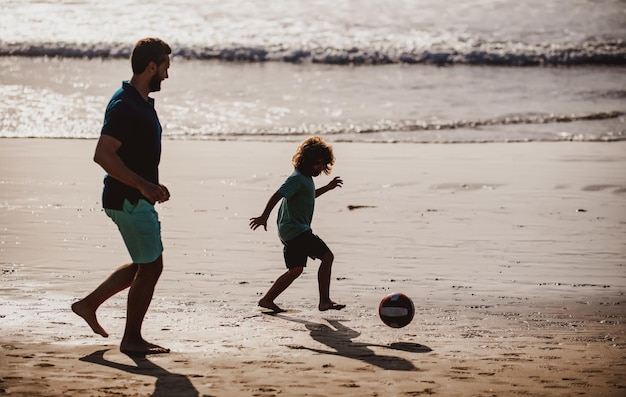 Vater und Kind spielen Outdoor-Silhouette bei Sonnenuntergang Vater und Sohn spielen Fußball oder Fußball auf der Be