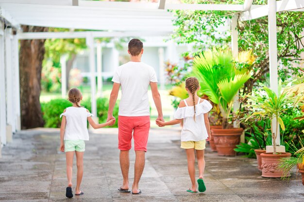 Vater und Kinder, die tropische Ferien des Strandsommers genießen