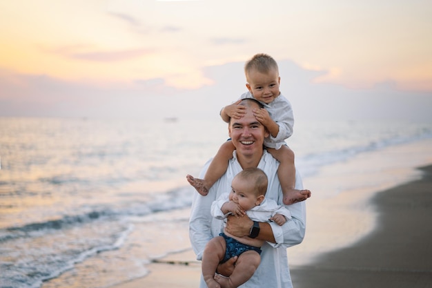 Vater und Kinder spielen am Strand. Vater und Kind genießen gemeinsam den Sonnenuntergang