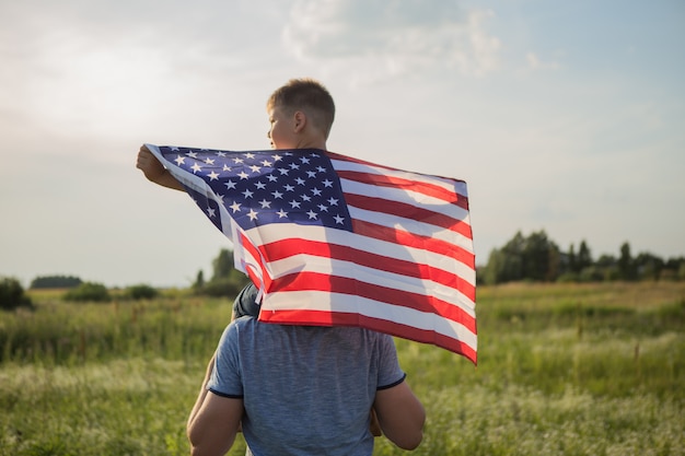 Vater und kleiner Junge halten die amerikanische Flagge