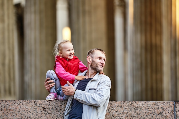 Foto vater und lächelndes baby gehen in der nähe von säulen