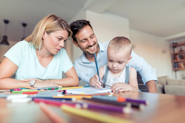 Vater und Mutter bringen seinem Sohn das Zeichnen bei