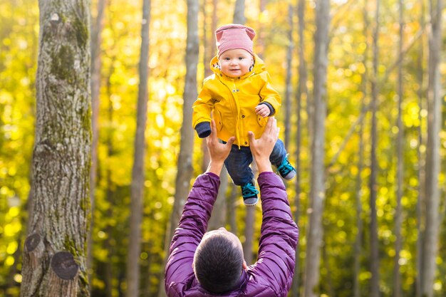 Vater und sein kleiner Sohn haben Spaß im Herbstpark