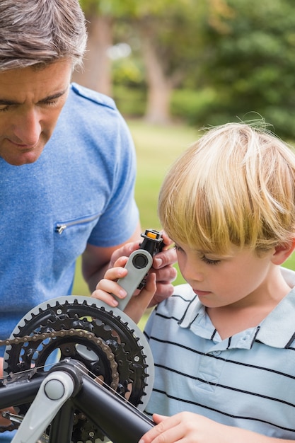 Vater und sein Sohn, die ein Fahrrad reparieren