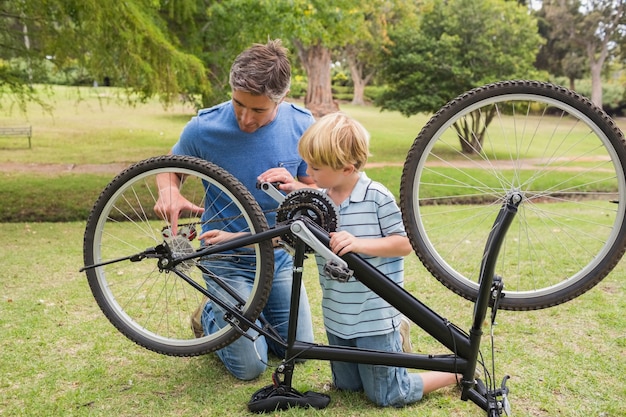 Vater und sein Sohn, die ein Fahrrad reparieren