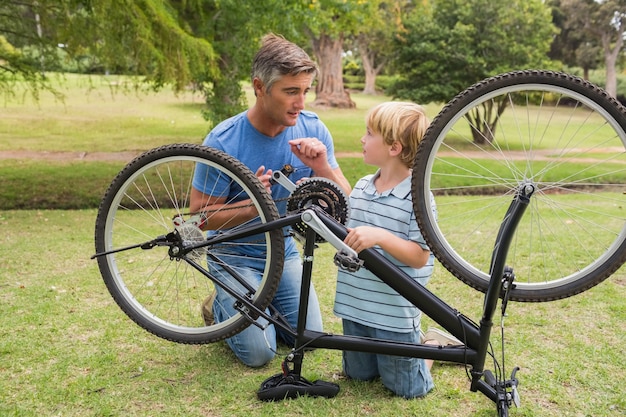 Vater und sein Sohn, die ein Fahrrad reparieren