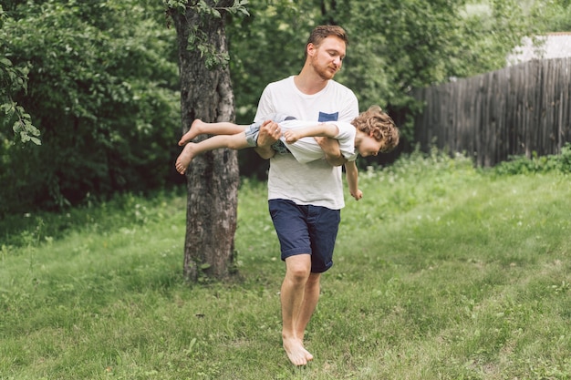 Vater und sein Sohn spielen und umarmen sich im Freien