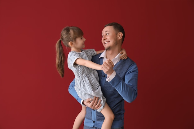 Vater und seine süße kleine Tochter tanzen auf Rot