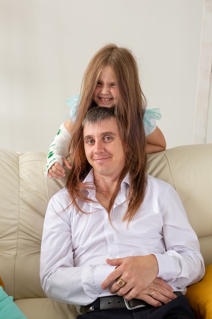 Vater und seine Tochter haben Spaß in ihrem Wohnzimmer kleines Mädchen hat eine Verletzungshand, aber sie ist es?