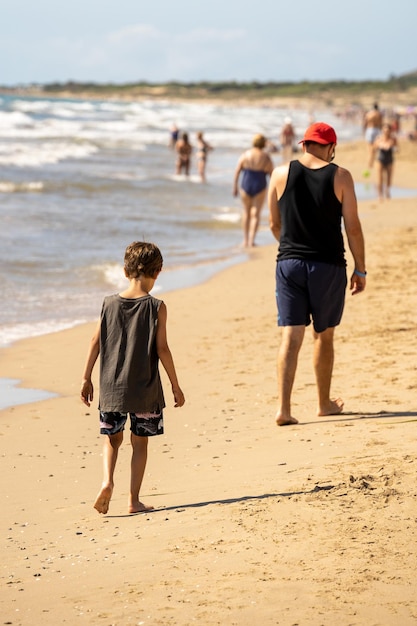 Vater und Sohn amüsieren sich am tropischen weißen Sandstrand Glückliche Familie am Strand Glücklicher Tagesausflug