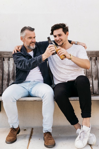 Foto vater und sohn auf bank mit bier