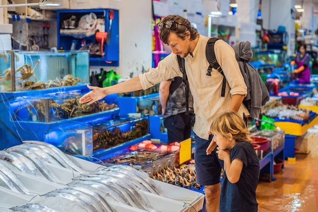 Vater und Sohn auf dem koreanischen Markt Rohe Meeresfrüchte auf dem Noryangjin Fisheries Wholesale Market in Seoul Südkorea Reisen mit Kindern Konzept