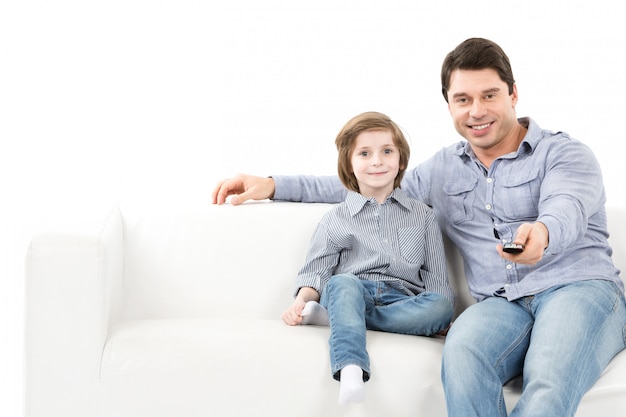 Vater und Sohn auf der Couch wechseln die Kanäle
