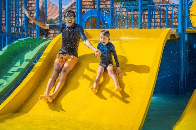 Vater und Sohn auf einer Wasserrutsche im Wasserpark