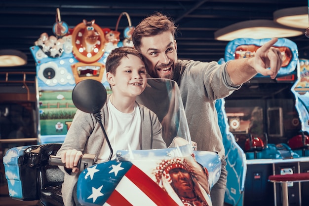 Vater und Sohn auf Spielzeugmotorrad. Familienerholung