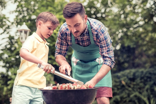 Vater und Sohn bei einer Grillparty