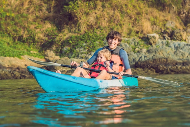 Vater und Sohn beim Kajakfahren im tropischen Ozean