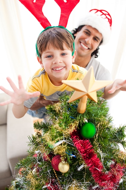 Vater und Sohn, die einen Weihnachtsbaum verzieren