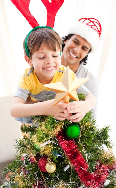 Vater und Sohn, die einen Weihnachtsbaum verzieren