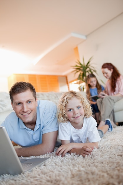 Vater und Sohn, die Internet auf dem Boden verwenden