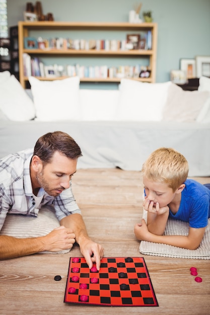 Vater und Sohn, die zu Hause Kontrolleurspiel spielen