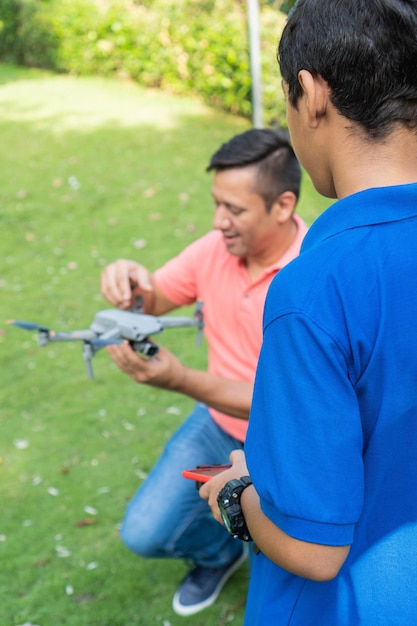 Vater und Sohn fliegen eine Drohne in einem Park