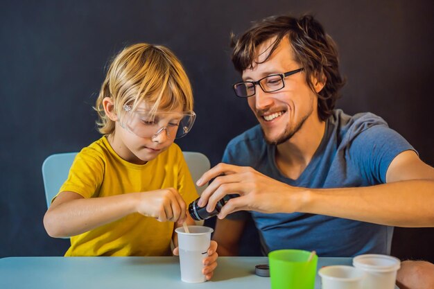 Vater und Sohn führen chemische Experimente zu Hause durch hausgemachten Schleim