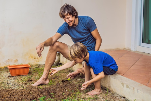 Vater und Sohn gärtnern im Garten in der Nähe des Hauses