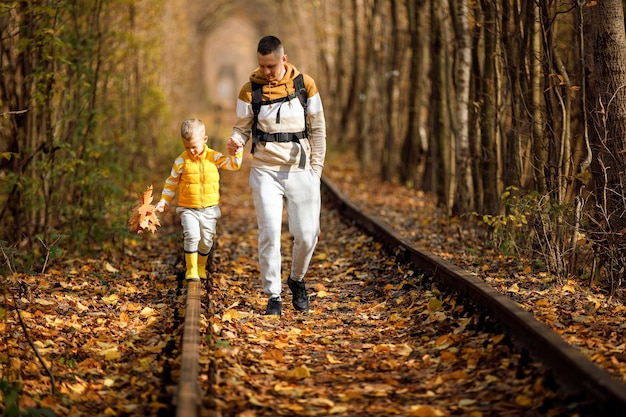 Vater und Sohn gehen auf der Eisenbahn auf Reisen Familie verbringt Zeit zusammen im Urlaub Vater und Sohn verbringen Zeit zusammen im Herbst