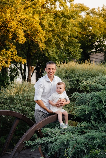 Vater und Sohn gehen im Park bei Sonnenuntergang. Glück. Liebe