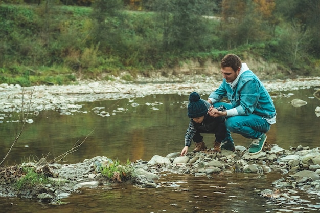 Vater und Sohn gehen und spielen zusammen. Der Herbst in den Bergen.