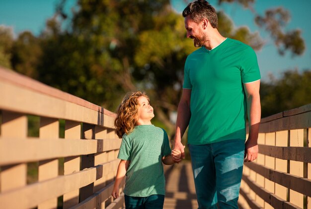 Vater und Sohn genießen Gesellschaft, unterhalten sich und haben Spaß in der Natur an einem sonnigen Tag. Elternschaftslebensstil