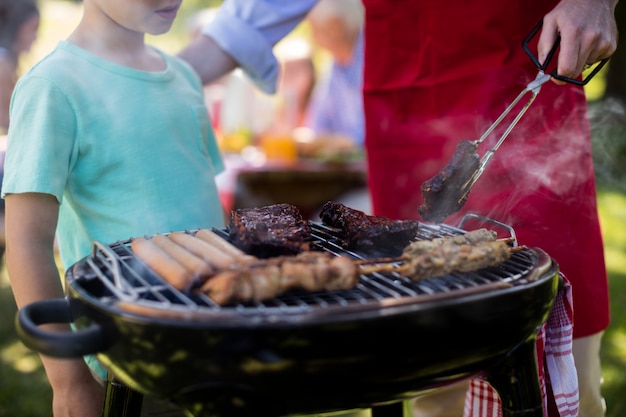 Vater und Sohn grillen im Park