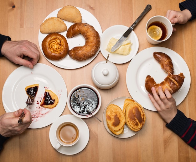 Vater und Sohn Hände am Frühstückstisch Teezeit Familienteeparty mit hausgemachten Pfannkuchen