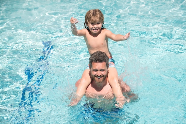 Vater und Sohn im Pool Sommerurlaub mit der Familie Poolparty Junge mit Papa spielt im Schwimmbad Aktiver Lebensstil