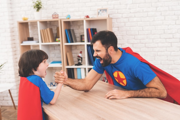 Vater und Sohn in Anzügen von Superhelden.