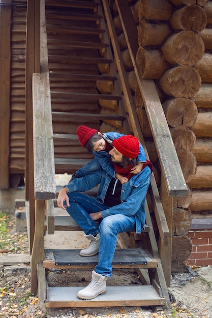 Vater und Sohn in roten Mützen und Strickschals sitzen