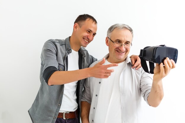 Vater und Sohn in virtuellen Gläsern, isolierte weiße Wand.