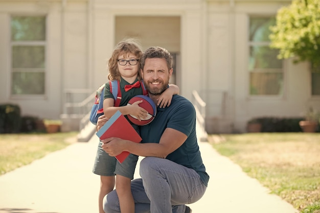 Vater und Sohn kommen von der Schule zurück. Glückliche Familie schätzt Kindheit und Elternschaft