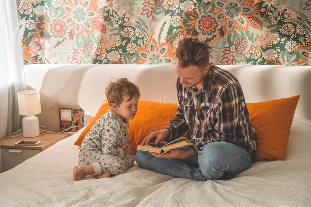 Vater und Sohn lasen zusammen ein Buch, lächelten und umarmten sich. Familienurlaub und Zusammensein